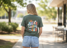 Load image into Gallery viewer, Person wearing a green t-shirt with colorful text outdoors