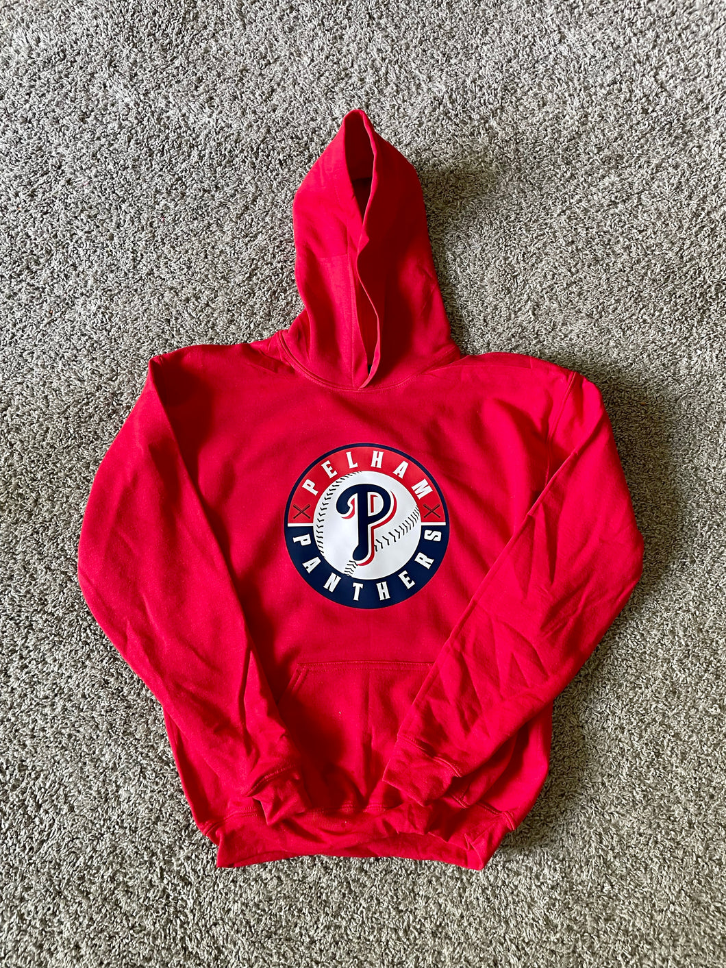 Red hoodie with a logo on a gray carpet