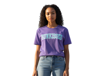 Load image into Gallery viewer, Person wearing a purple &#39;SUNKISSED&#39; t-shirt on a white background
